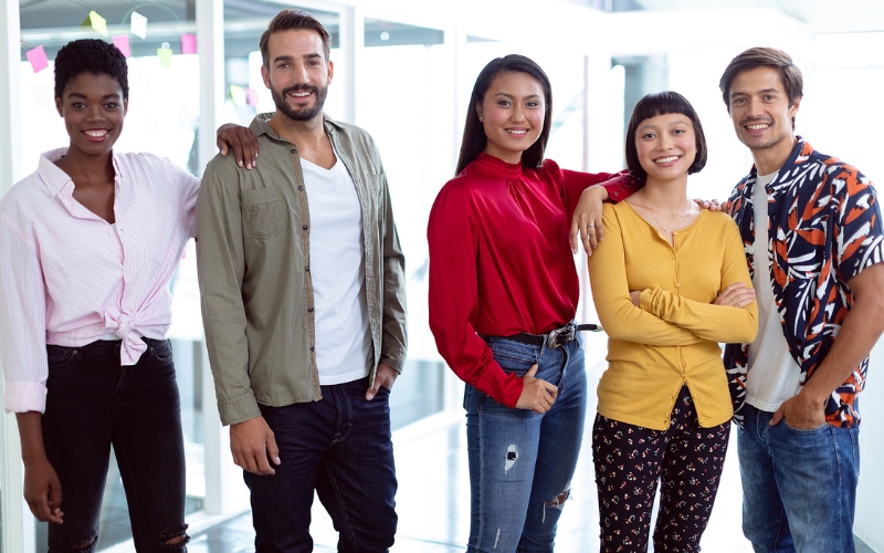 Group of diverse young people standing side by side smiling